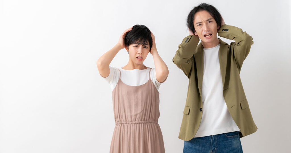 頭を抱える男女